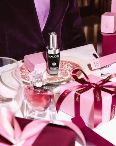 Lancome beauty termekek es rozsaszin ajandekdobozok unnepi asztalon elrendezve.