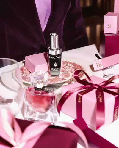 Lancome beauty termekek es rozsaszin ajandekdobozok unnepi asztalon elrendezve.