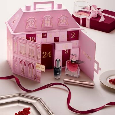 Nyitott rozsaszin Lancome varosi palota formaju adventi kalendarium beauty termekekkel es piros szalaggal.