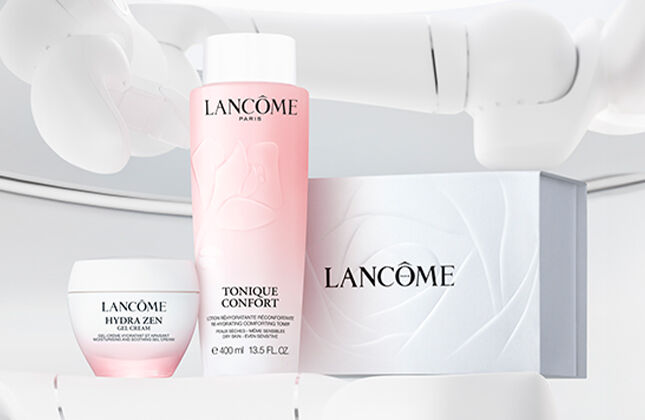 A clean, minimalistic display featuring Lancome skincare products, including a lotion, cream, and box on a light background.