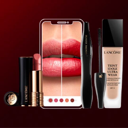 A kepen egy kez tart egy okostelefont, amelyen szajfeny szinmintai lathatok a Lancome markatol.