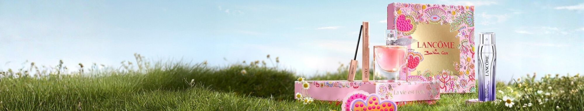 Lancome unnepi ajandekkeszletek rozsaszin vintage stilusu dobozokban, havas hegyi hatterrel.