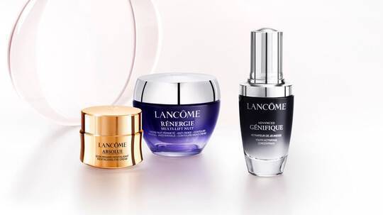 Harom Lancome bőrapolo termek: Absolue, Renergie es Genifique, elegans feher hatter előtt.