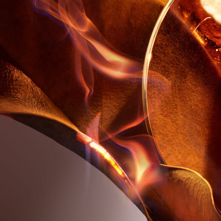 A kep egy hajlitott, barna texturaju feluletet mutat be, amelyen langok kanyarognak, meleg szinekben jatszva.