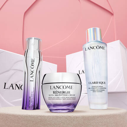 Harom Lancome szepsegapolasi termek: Renergie H.P.N. 300-Peptide Cream, Renergie krem es Clarifique esszencia, egy elegans hatter előtt.