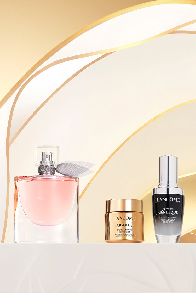 A kepen egy Lancome parfum es bőrapolo termekek lathatok, arany szinu hatter előtt, elegans elrendezesben.